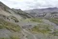 Wanderer auf einem Bergpfad in einer bergigen Landschaft.