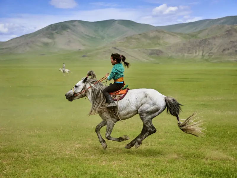 Auf dieser Expeditionsreise durch die Mongolei begegnen Sie auch immer wieder Nomaden - da kann auch mal ein junges Mädchen auf seinem Pferd durch die Steppe preschen