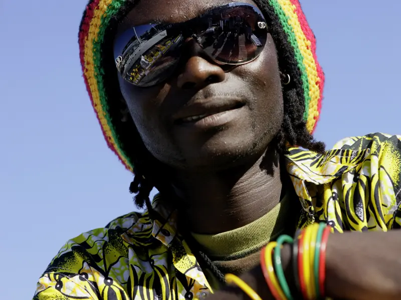 Ein junger Mann mit Rastafari-Mütze und Sonnenbrille blickt uns an. Nur eine Begegnung von vielen auf der Studiosus-Südafrikareise.