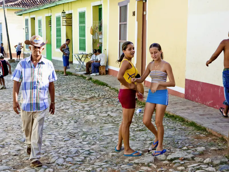 Straßenszene in Kuba. Unsere Rundreise auf der bildschönen Karibikinsel ist ebenso spannend wie entspannend. Wir wohnen, passend für die kleine Gruppe, mitten in den schönsten Altstädten Kubas in Boutique-Hotels mit Kolonialflair.