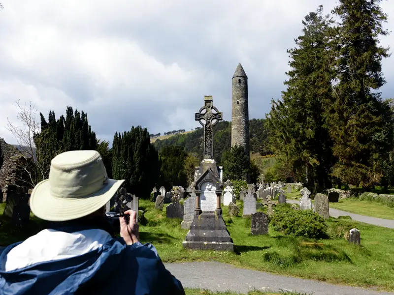 Auf unserer Singlereise durch Irland führt Sie ihr Reiseleiter gekonnt durch die irische Geschichte, wie hier am Kloster von Glendalough mit dem Rundturm der Anlage.