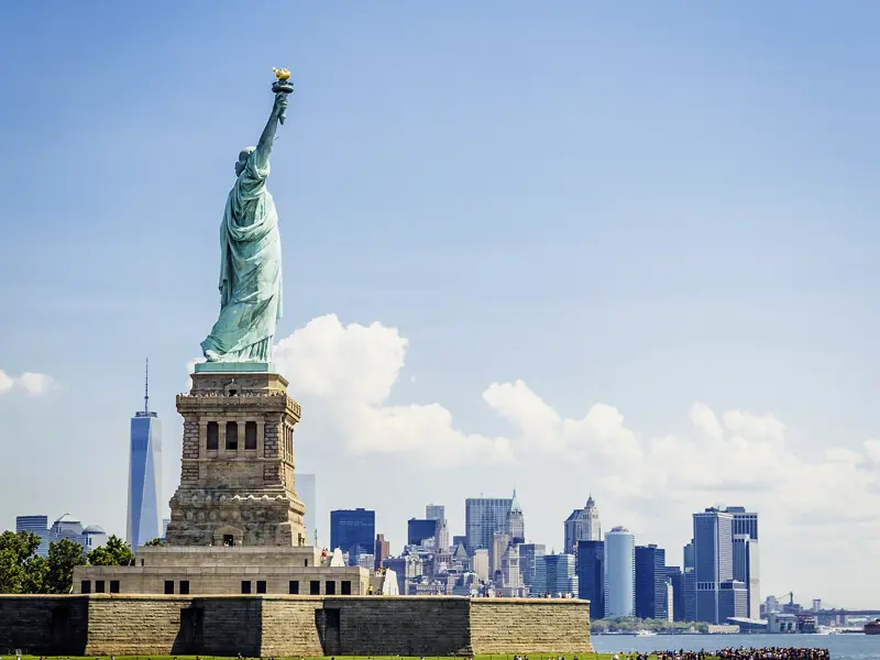 Wir genießen jeden Augenblick auf unserer CityLights-Städtereise nach New York. Vor der Skyline von Manhattan grüßt uns die Freiheitsstatue.