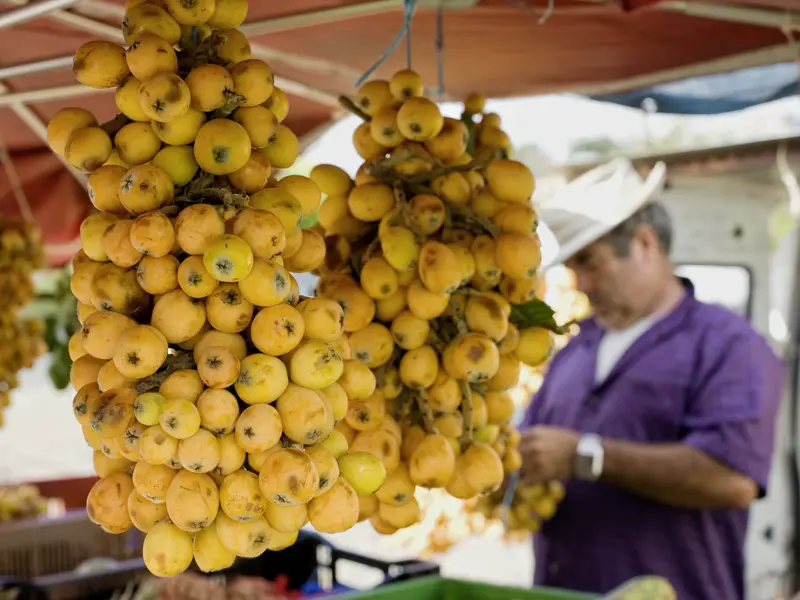 Auf einem Markt auf Réunion hängen Mispeln zum Verkauf