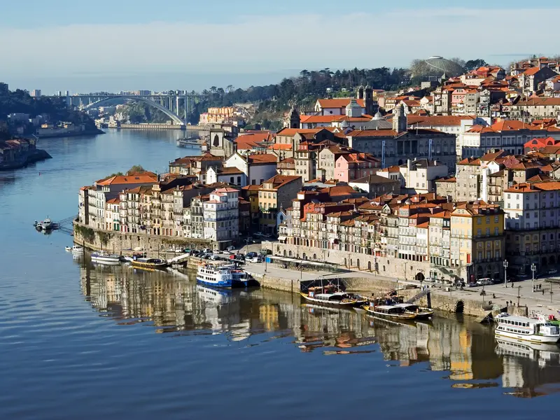 Auf unserer Wanderreise durch Portugal erkunden wir die Altstadt von Porto am Ufer des Douros.  Auf den zahlreichen Booten werden nicht nur Touristen, sondern immer noch Portweinfässer transportiert.