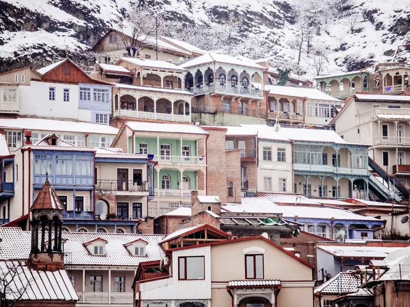 Auf unserer Silvesterreise für Singles und Alleinreisenden erfreuen uns am ganz besonderen Charme von Tiflis im Winter, wenn in Georgiens Hauptstadt die bunten Häuser verschneit sind.