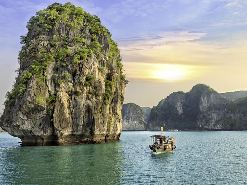 Die Halongbucht: Wie versteinerte Riesen tauchen aus den smaragdgrünen Fluten die Kegel der Karstlandschaft auf. Unser Blick wandert durch die unwirkliche Szenerie, wir kommen auf unserer umfassenden Studienreise durch Vietnam und Kambodscha am Meer zur Ruhe.