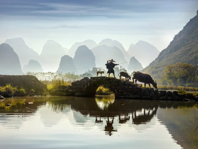 Reis- und Lotosfelder, Bambushaine, Höhlen, Dörfer und grün bewachsene Kegelkarstberge: Die Landschaft rund um Yangshuo ist pure Magie. Wir lassen uns verzaubern, während uns der Li-Fluss bis ins Städtchen Fuli trägt. Ein Highlight unserer Studienreise durch China.