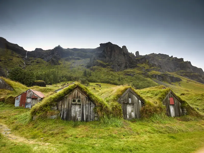 Auf unserer umfassenden Reise durch Island begegnen wir inmitten hügeliger Wiesenlandschaften den traditionellen Grassodenhäusern, die den Isländern über Jahrhunderte Schutz geboten haben.