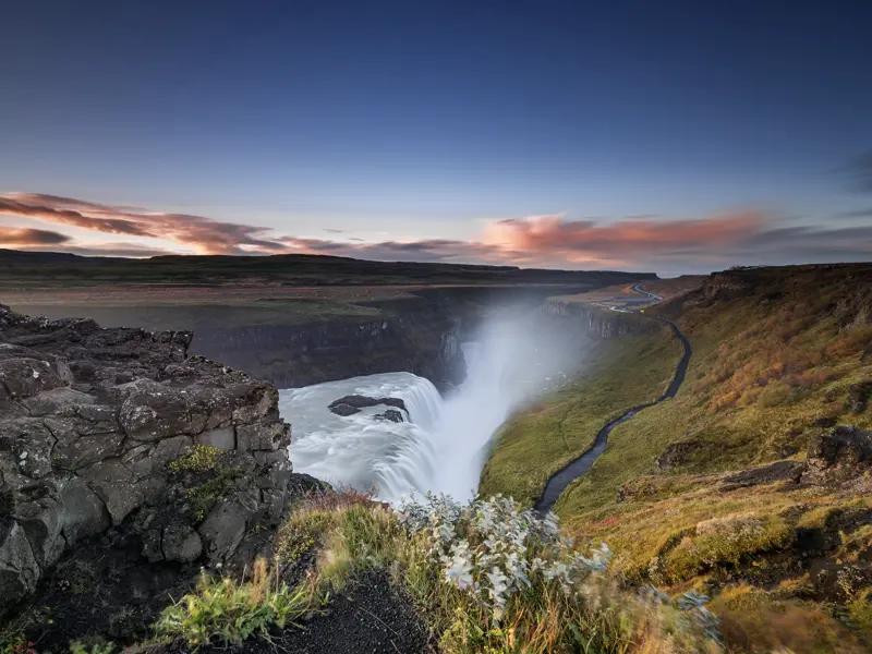 Auf unserer Studienreise durch Island führt die Fahrtauf der  Ringstraße einmal um die Insel. Wir haben viele Gelegenheiten, uns die einzigartigen Naturschauspiele näher anzuschauen. Im Südwesten Islands beeindruckt uns der Wasserfall Gullfoss, dort tost das Wasser über zwei Stufen in die Tiefe.