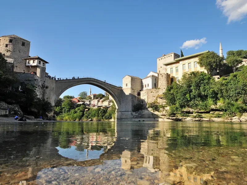 Mostar liegt malerisch am Fluss Neretva. Wir erkunden auf unserer Studienreise durch den Balkan die Gassen der Altstadt und überqueren die legendäre Alte Brücke, Symbol des Friedens (UNESCO-Welterbe).