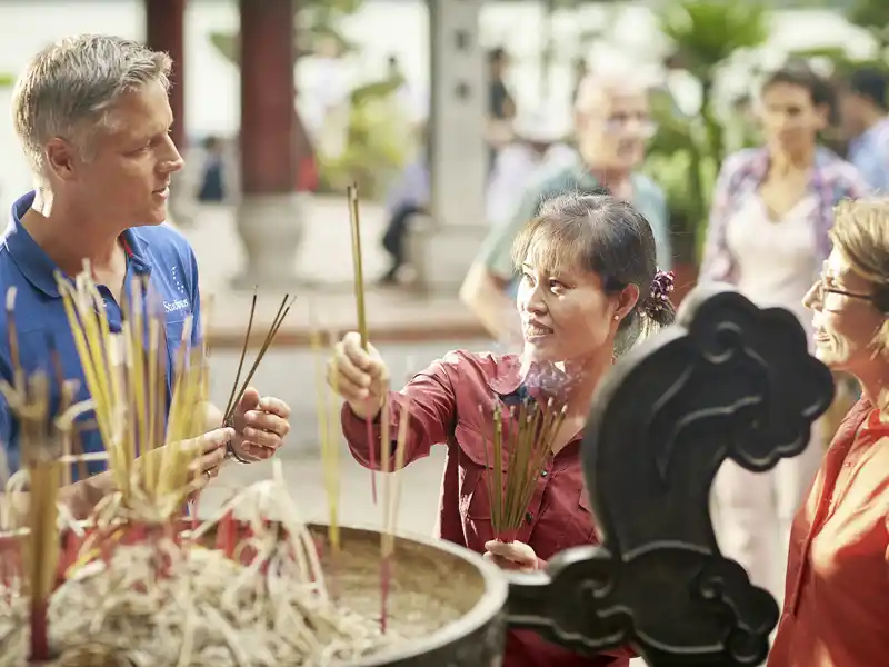 Auf unserer Reise für Singles und Alleinreisende durch Vietnam besuchen wir einen Tempel in Saigon und zünden Räucherkerzen an.