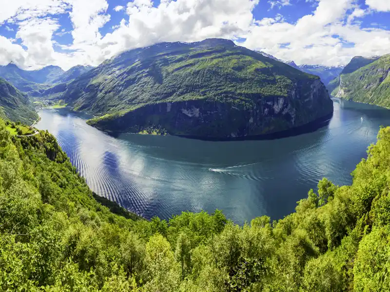 Den Geirangerfjord erleben wir auf unserer Reise durch Norwegen während einer Fährüberfahrt an Wasserfällen und Felswänden entlang.