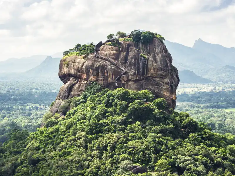 Auf unserer Rundreise durch Sri Lanka erklimmen wir die vielen Treppenstufen, die zum Löwenfelsen Sigiriya hinaufführen. Auf halbem Weg besuchen wir die Freskenmalerei der Wolkenmädchen.