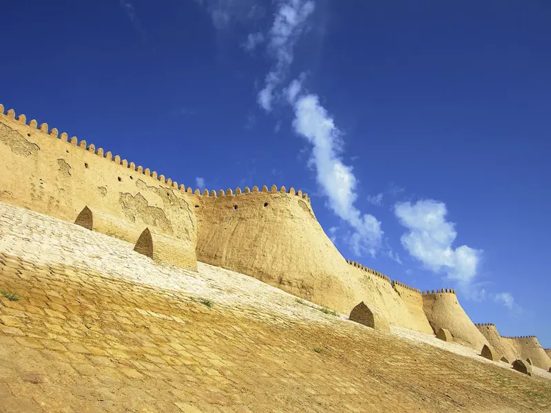 Auf unserer Rundreise durch Usbekistan wohnen wir in Chiwa direkt in der Altstadt, innerhalb der sandfarbenen Festungsmauern.