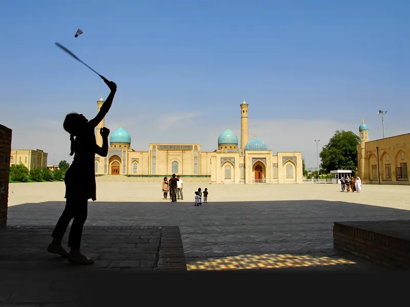 Auf unserer Reise durch Usbekistan sehen wir Szenen aus dem Alltagsleben wie ein Federball spielendes Mädchen im Hof vor einer Koranschule.