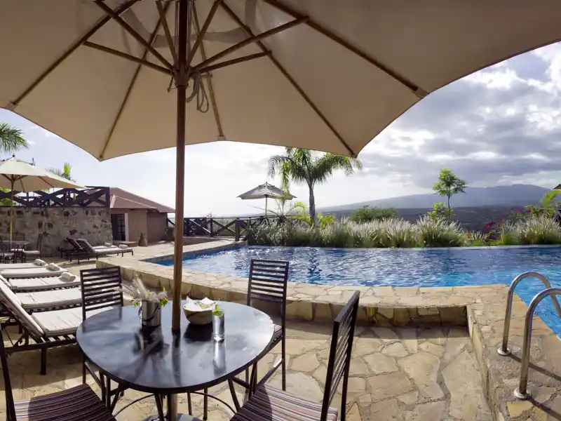 Auf der smart & small-Rundreise durch Tansania für zwei Tage unsere Farm in Afrika: die Bashay Rift Lodge bei Karatu mit Panoramablick von der Terrasse und mit Pool.