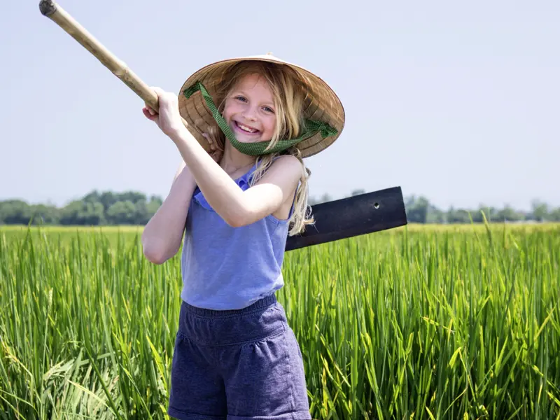 Auf unserer 14-tägigen Familienreise durch Vietnam haben Kinder und Eltern die Gelegenheit Bauer Xua bei der Arbeit auf dem Reisfeld in der Nähe von Hoi An zu helfen.