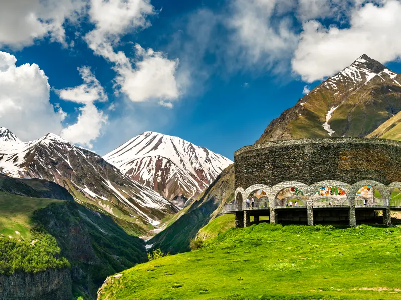 In Georgien, auf dem Weg nach Stepantsminda, fahren wir bei 14-tägigen Studienreise durch den Südkaukasus auch zu einem Aussichtsplatz am Kreuzpass im Großen Kaukasus.