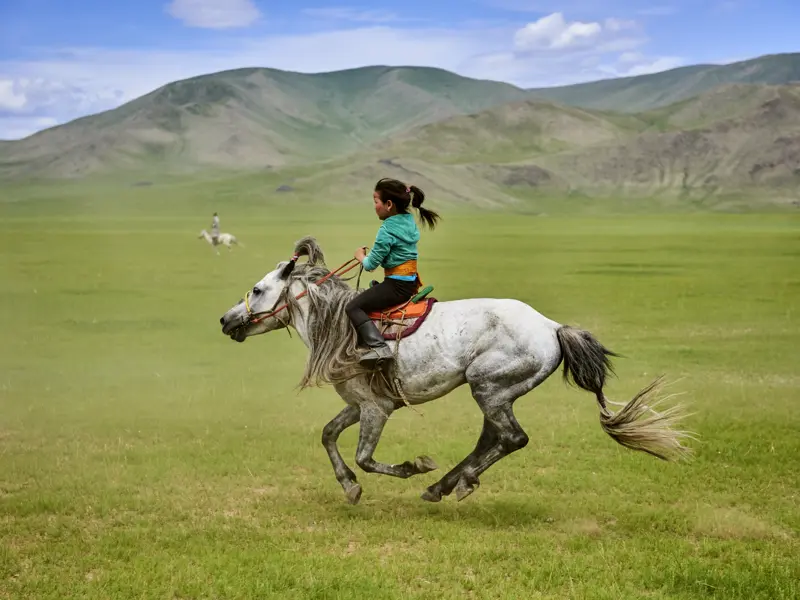 Auf dieser Expeditionsreise durch die Mongolei begegnen Sie auch immer wieder Nomaden - da kann auch mal ein junges Mädchen auf seinem Pferd durch die Steppe preschen.
