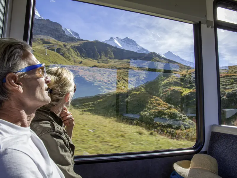 Die Schweiz lässt sich entspannt mit der Bahn bereisen - so wie wir das auf unserer Studienreise machen und Berge und Almen am Zugfenster vorbeiziehen lassen.