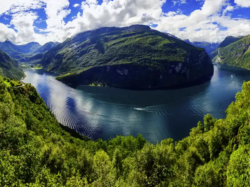 Den Geirangerfjord erleben wir auf unserer Reise durch Norwegen während einer Fährüberfahrt an Wasserfällen und Felswänden entlang.