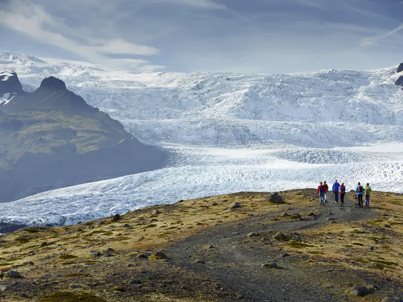 Während der preiswerten Rundreise mit Studiosus durch Island spazieren wir an der Gletscherlagune Fjallsarlon entlang. Im Hintergrund ist der mächtige Gletscher Vatnajökull zu sehen.