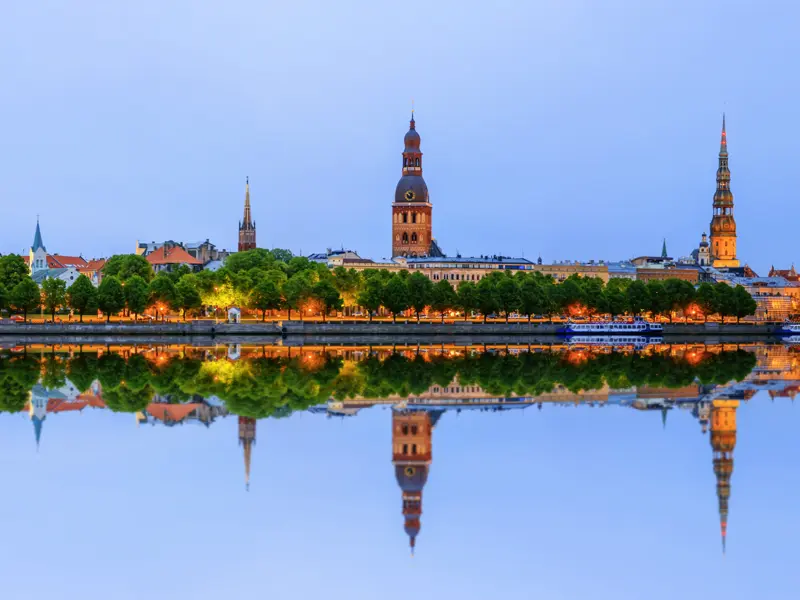 Die Studienreise mit dem Komfortbus bis nach Helsinki führt auch in die lettische Hauptstadt Riga. In der Dämmerung herrscht am Ufer der Daugava eine ganz besondere Stimmung.