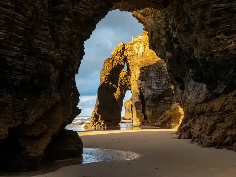 Der Strand der Kathedralen von Ribadeo präsentiert sich uns auf unserer Gruppenreise mit Studiosus bei Ebbe besonders eindrucksvoll: Wind und Wetter meißelten an den Felstoren, die sich wie gotische Strebebögen an die Küste anlehnen.