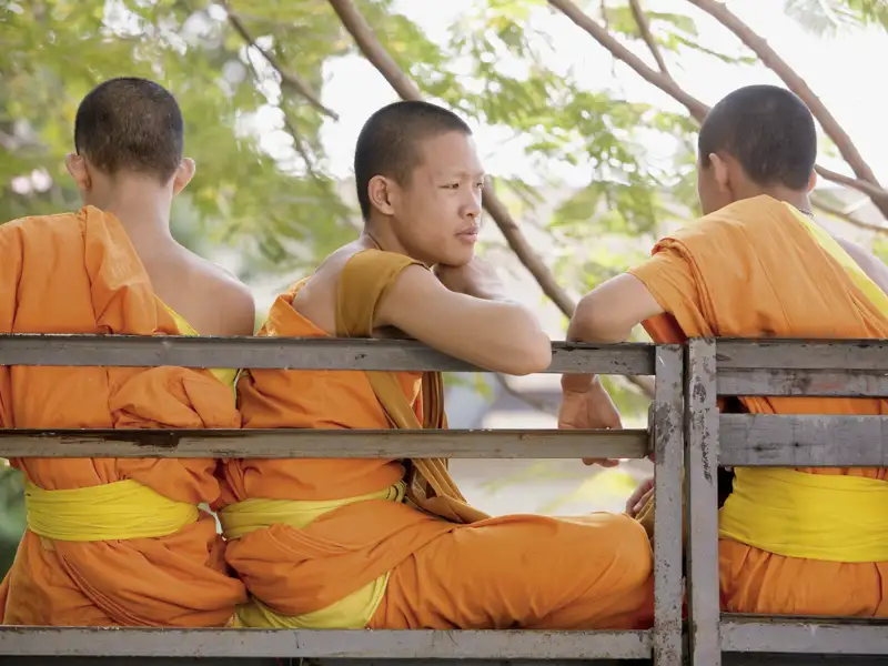 Das Licht ist noch milchig, wenn die Mönche ihre Runde drehen und die Gaben der Gläubigen entgegennehmen. Ein uraltes Ritual. Auf Ihrer Reise durch Thailand lauschen wir der Segnungszeremonie und dem abendlichen Mönchsgesang.