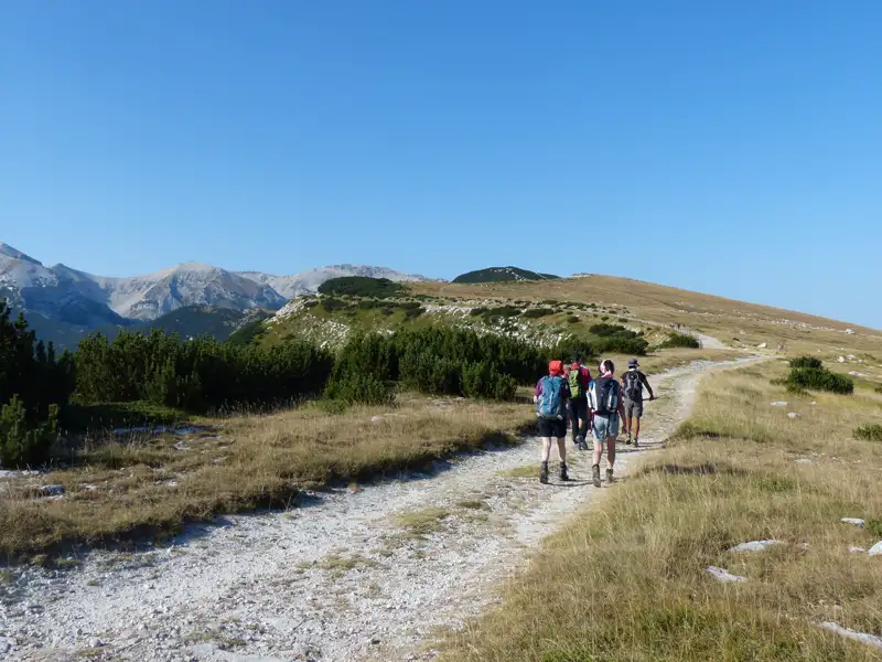 Wanderer auf einem Bergpfad in einer Berglandschaft.