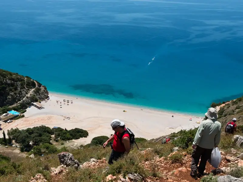 Wanderer auf einem Pfad mit Blick auf einen abgelegenen Strand.