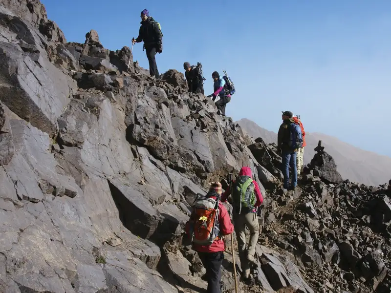 Wanderer auf einem felsigen Bergpfad.