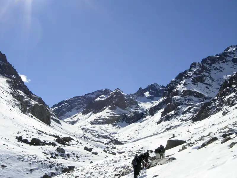 Wanderer auf einem verschneiten Bergpfad.