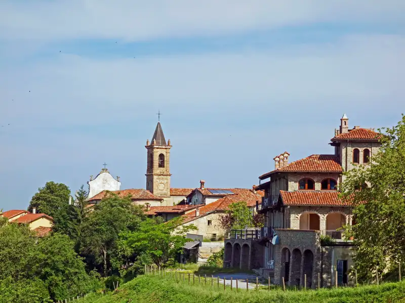 Panorama eines italienischen Dorfes mit Kirche und traditionellen Häusern.
