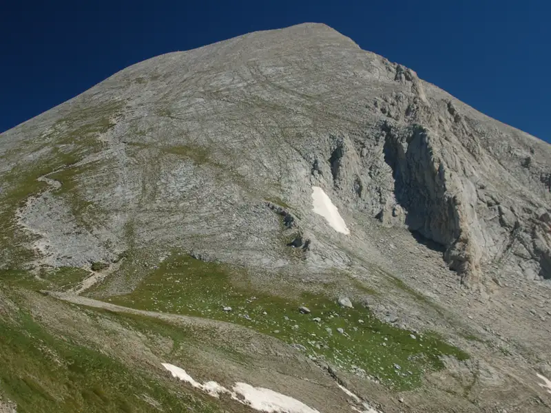 Felsiger Berggipfel mit Schneefeldern.