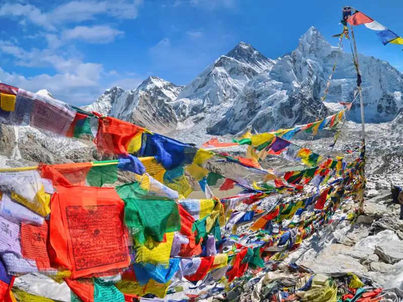 Gebetsfahnen im Vordergrund mit Blick auf den schneebedeckten Mount Everest.