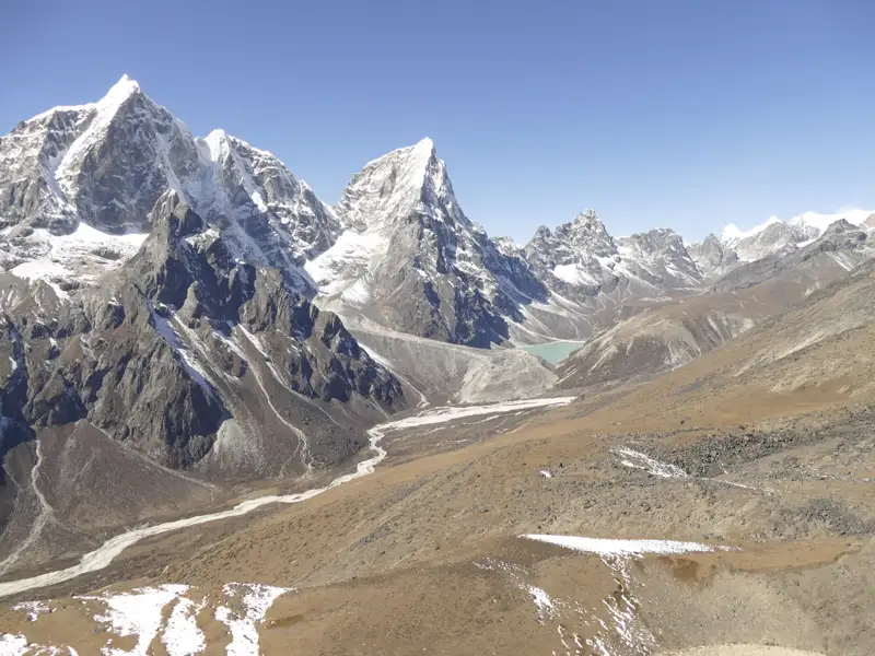 Panorama der Himalaya-Bergkette mit Schnee, Felsen und einem Tal.