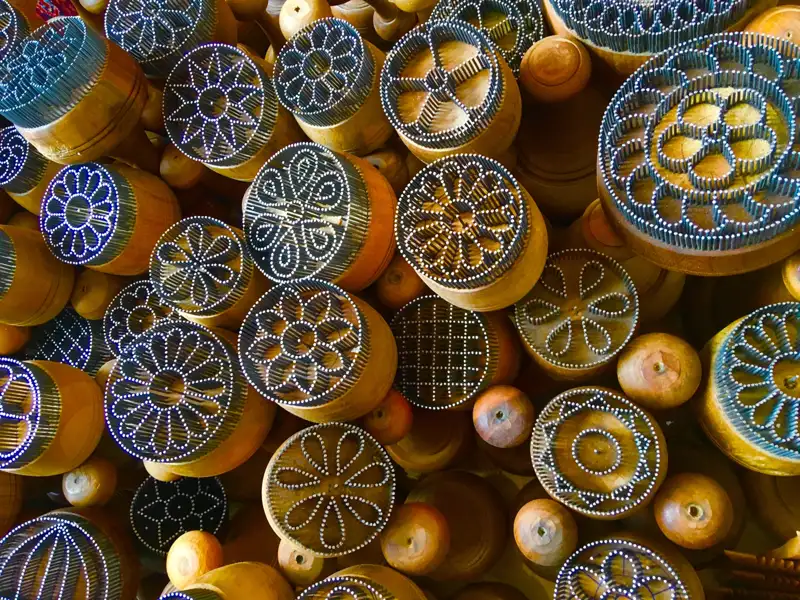 Holzstempel mit verschiedenen floralen und geometrischen Mustern, angeordnet in einer Gruppe.