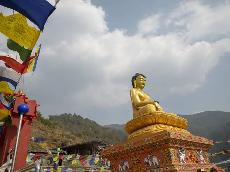 Goldene Buddha-Statue und Gebetsfahnen.