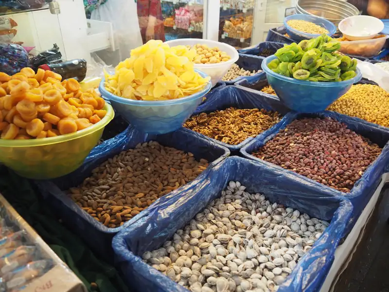 Auslage mit verschiedenen Trockenfrüchten und Nüssen auf einem Markt.