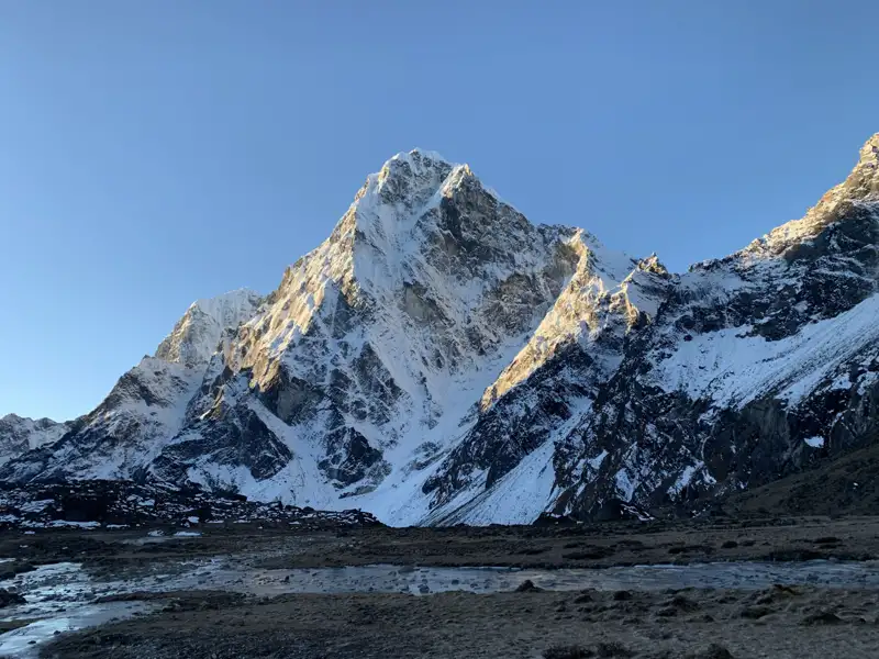 Schneebedeckter Berggipfel im Morgenlicht.