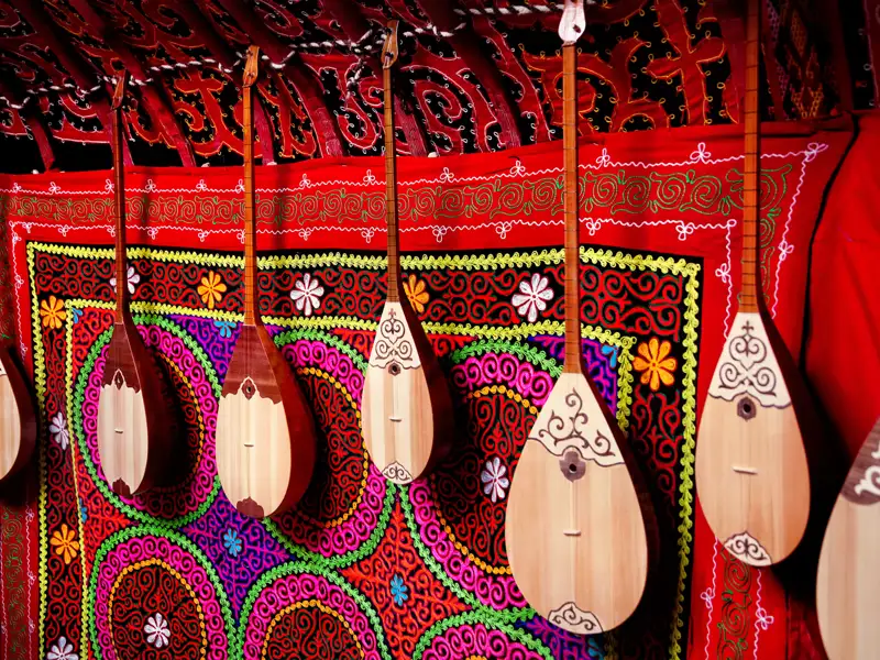 Dombra, traditionelle kasachische Saiteninstrumente, an einer farbenfrohen Wand.