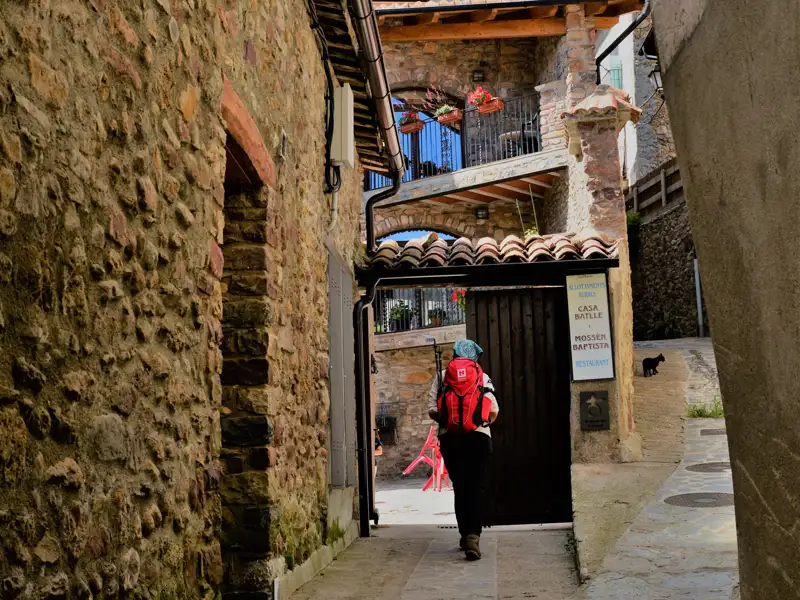 Wanderer mit Rucksack in einer alten Gasse.