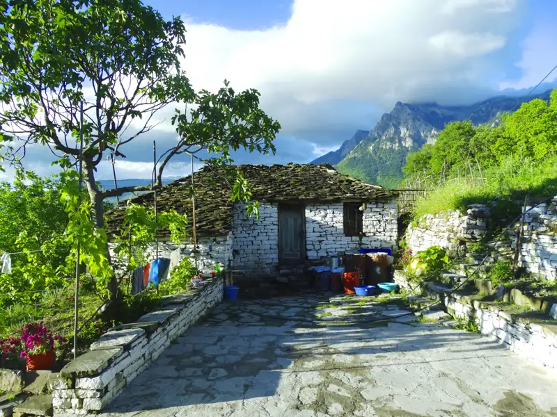 Traditionelles Steinhaus mit Schieferdach in den Bergen.