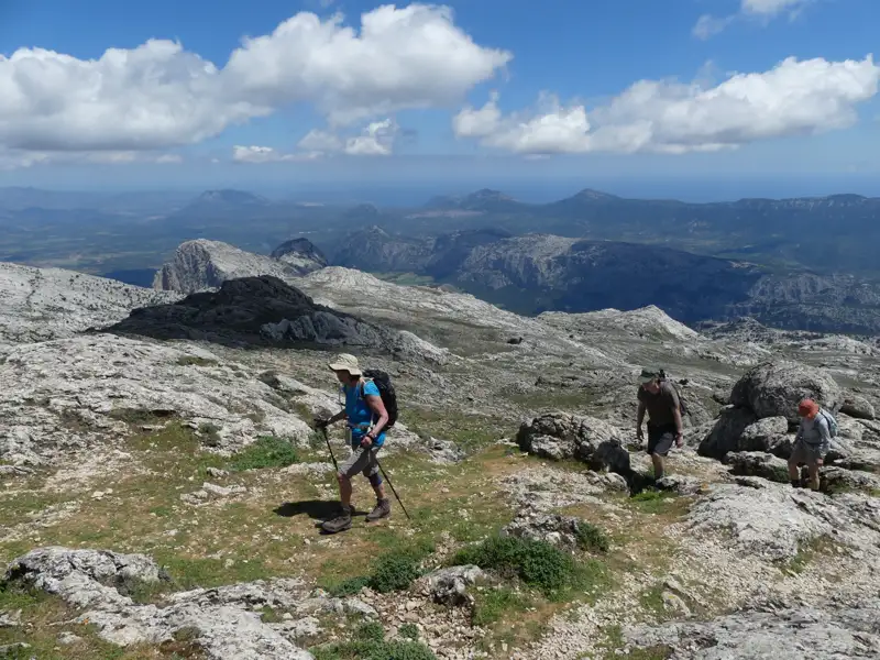 Wanderer auf einem Bergpfad mit Blick auf die Landschaft.