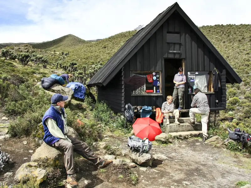 Wanderer bei einer Rast an einer Berghütte während ihrer Wanderung.
