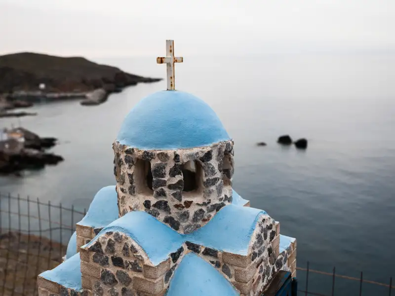 Blau-weiße Kapelle an der Küste mit Blick auf das Meer.
