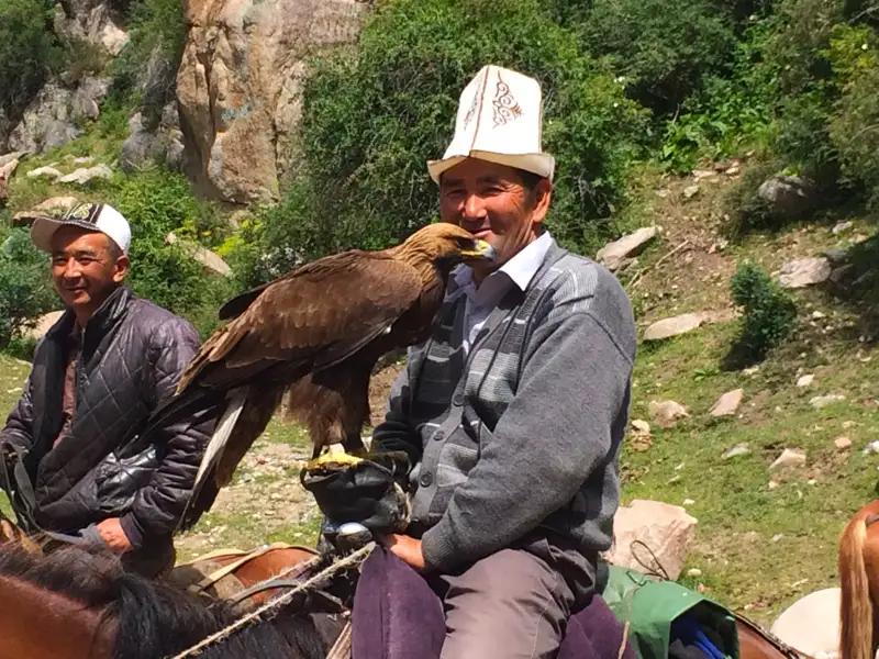 Traditioneller Adlerjäger mit seinem Steinadler auf einem Pferd.