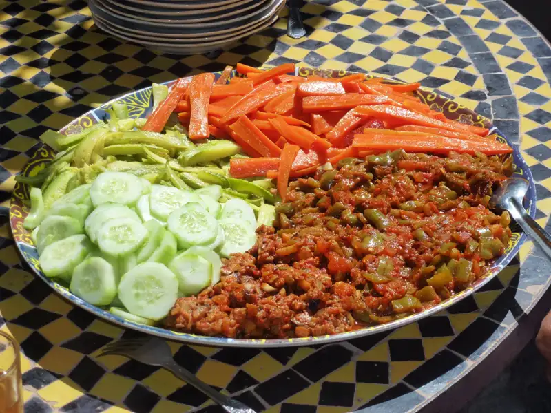 Gemüseplatte mit Gurken, Zucchini, Karotten und einem Paprika-Tomaten-Gericht.