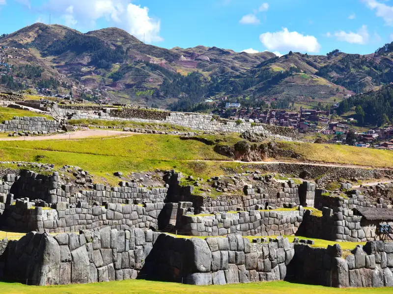 Detailansicht der Inka-Steinmauern mit den Anden im Hintergrund.